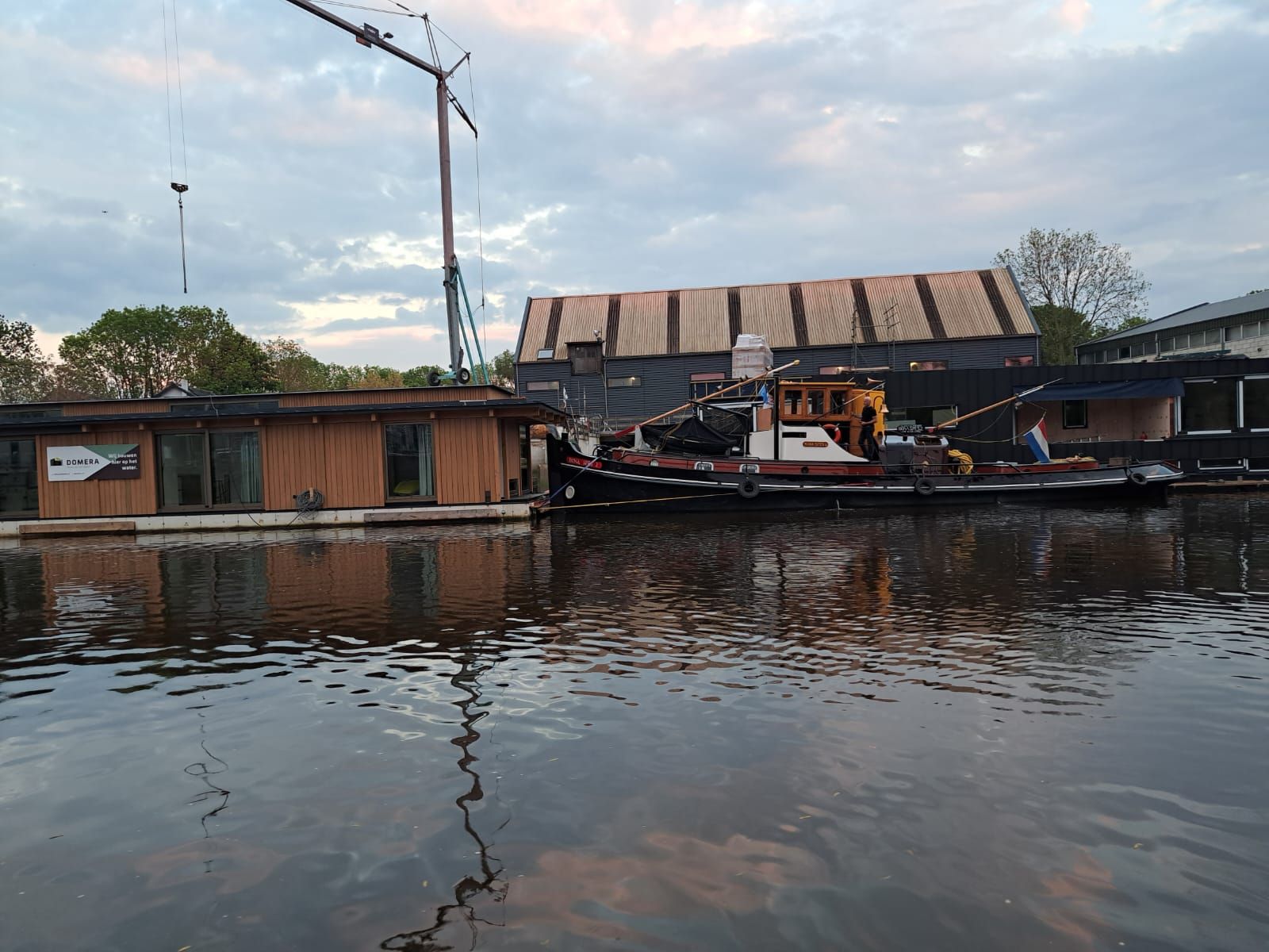 De werf van Domera in Gouda met de bouwhal, een kraan en een sleepboot